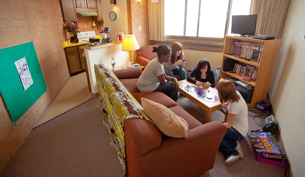 Students playing board games in the living room of an apartment.